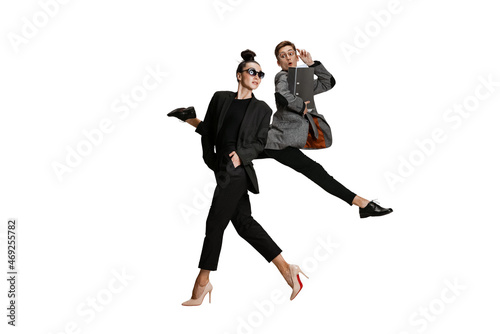 Two stylish office workers in business suits in action isolated on white background. Art, beauty, fashion and business concept