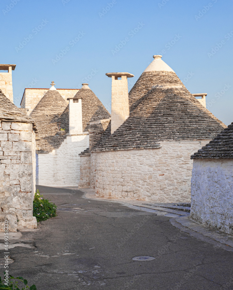 white traditional southern italian trulli village houses with tapered stone roofs