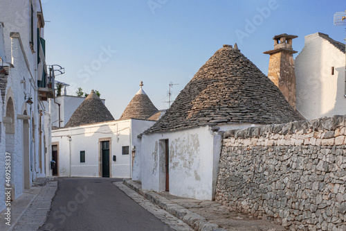 white traditional southern italian trulli village houses with tapered stone roofs