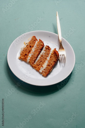 Plate with a piece of carrot cake on light green background pattern minimallistic bright shot