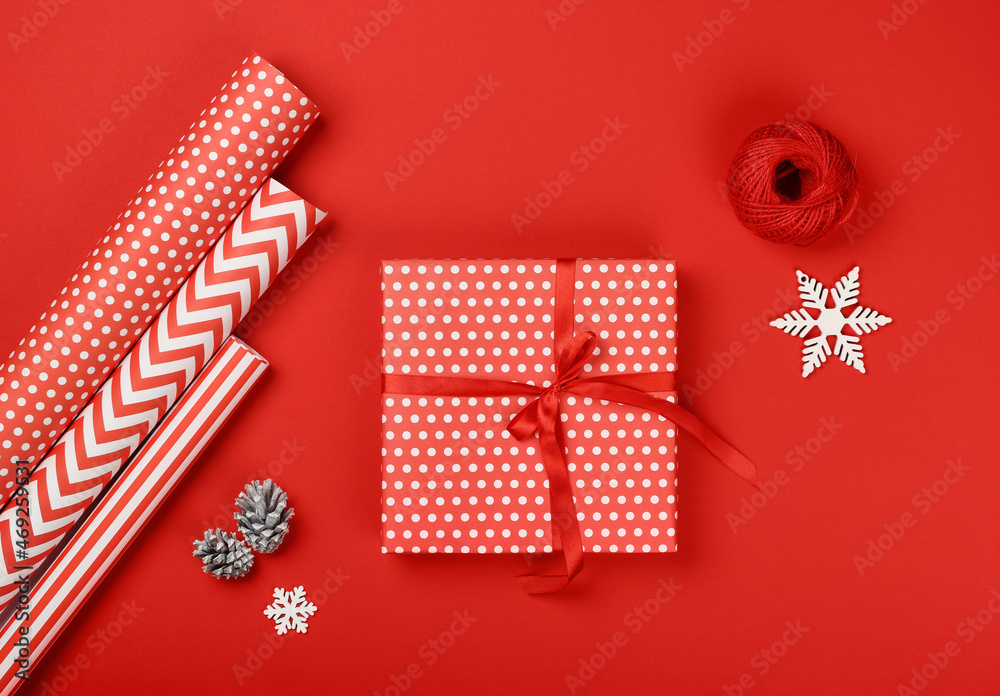 Fototapeta premium Packing Christmas gifts with red and white paper