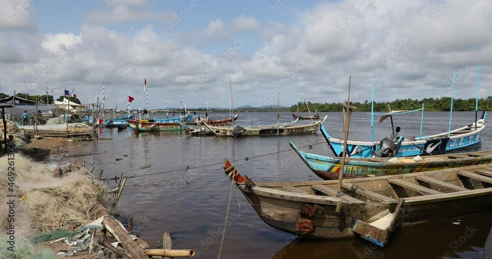 Colorful Traditional wooden fishing boats village Liberia Africa. West African country with dark history Civil wars, Ebola and COVID and economic failures stagnated economic growth. Colorful Traditional wooden fishing boats village Liberia Africa. West African country with dark history Civil wars, Ebola and COVID and economic failures stagnated economic growth.
