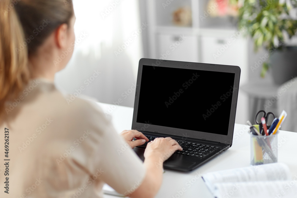education, online school and distant learning concept - student woman with laptop computer and book typing at home education, online school and distant learning concept - student woman with laptop computer and book typing at home