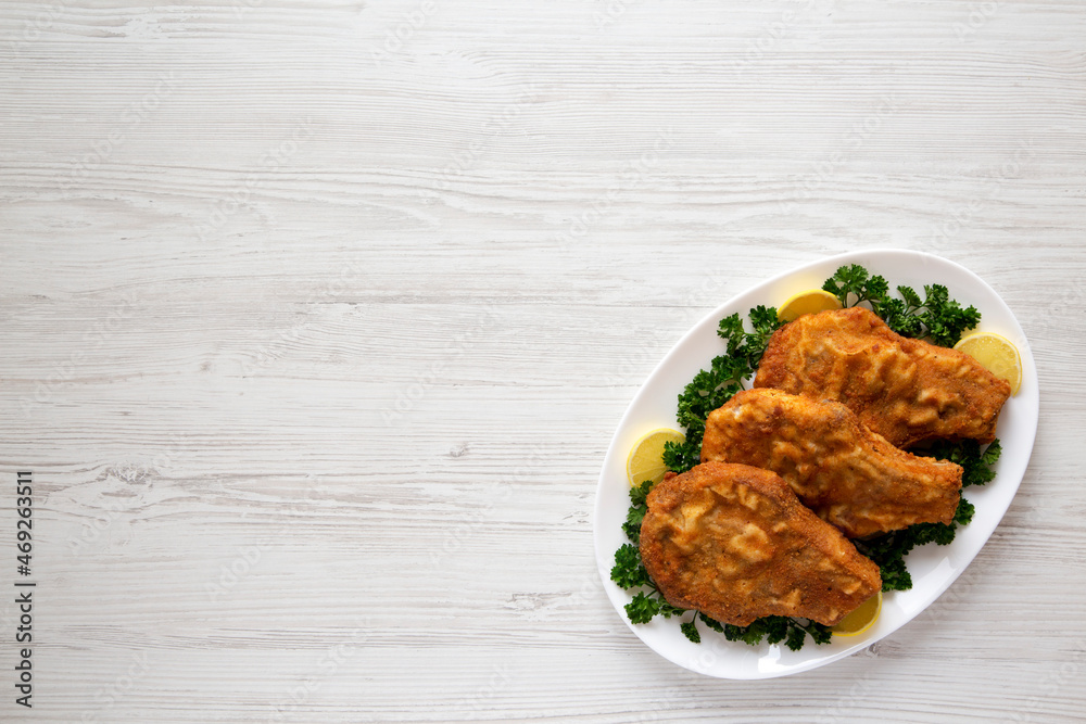 Homemade Fried Pork Chops on a White Plate, top view. Flat lay, overhead, from above. Space for text. Homemade Fried Pork Chops on a White Plate, top view. Flat lay, overhead, from above. Space for text.