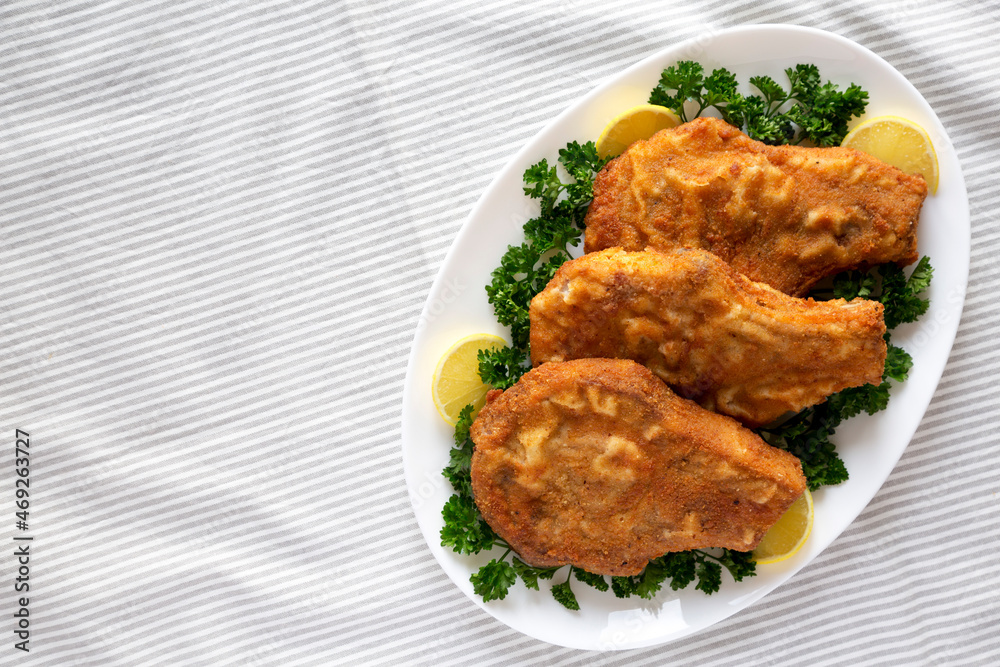 Homemade Fried Pork Chops on a White Plate, top view. Flat lay, overhead, from above. Space for text. Homemade Fried Pork Chops on a White Plate, top view. Flat lay, overhead, from above. Space for text.