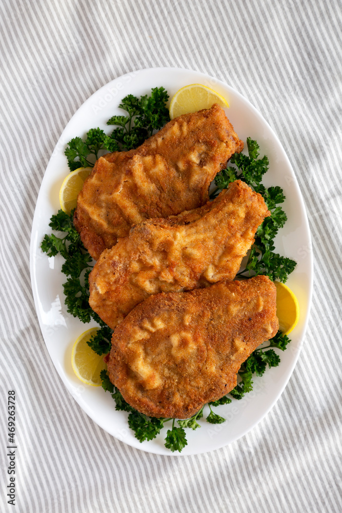 Homemade Fried Pork Chops on a White Plate, top view. Flat lay, overhead, from above. Homemade Fried Pork Chops on a White Plate, top view. Flat lay, overhead, from above.