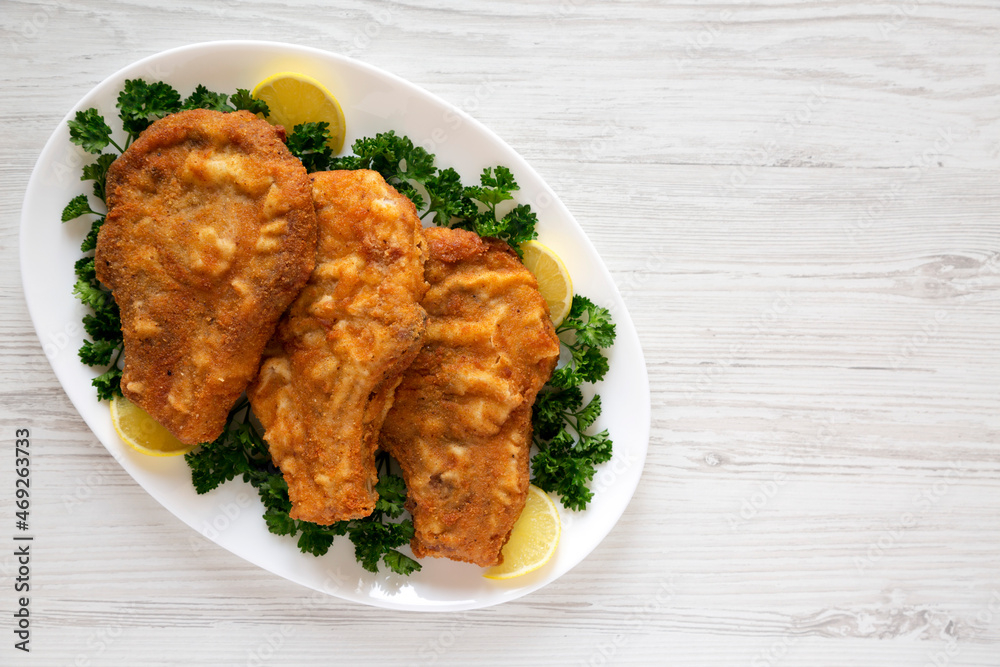 Homemade Fried Pork Chops on a White Plate, top view. Flat lay, overhead, from above. Copy space. Homemade Fried Pork Chops on a White Plate, top view. Flat lay, overhead, from above. Copy space.