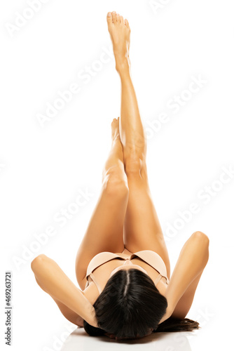 pretty woman posing lying down on the floor with her legs up