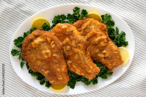 Homemade Fried Pork Chops on a White Plate, top view. Flat lay, overhead, from above.