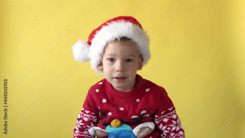 Portrait Emotion Cute Happy Cheerful Chubby Preschool Baby Boy Smiling Fooling Around in Santa Hat Looking On Camera At Yellow Background. Child Christmas Celebrating. Kid Have Fun Spend New Year Time Portrait Emotion Cute Happy Cheerful Chubby Preschool Baby Boy Smiling Fooling Around in Santa Hat Looking On Camera At Yellow Background. Child Christmas Celebrating. Kid Have Fun Spend New Year Time