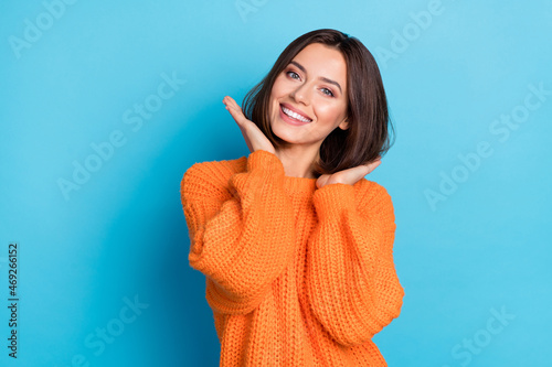 Portrait of attractive cheerful well-groomed girl touching soft smooth hair isolated over bright blue color background