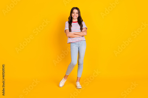 Full size photo of young schoolgirl happy positive smile confident crossed hands isolated over yellow color background