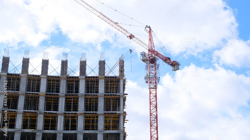 Construction industry. High rise building under construction and construction crane up to the sky. Housing construction, apartment building in the city, mortgage Construction industry. High rise building under construction and construction crane up to the sky. Housing construction, apartment building in the city, mortgage