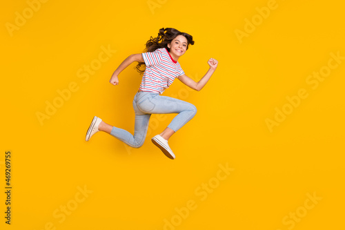 Full body profile side photo of young excited girl happy smile jump up run hurry sale isolated over yellow color background