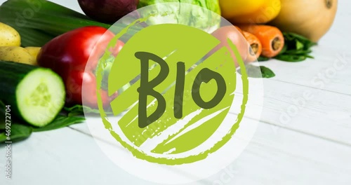 Animation of bio text in green, on green circle, over fresh vegetables on white boards photo