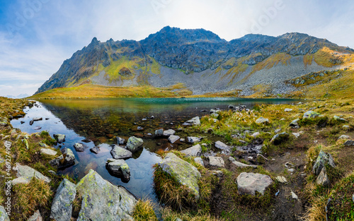 Rocky shore of Herzsee lake inOtztal Alpsduring autumn photo