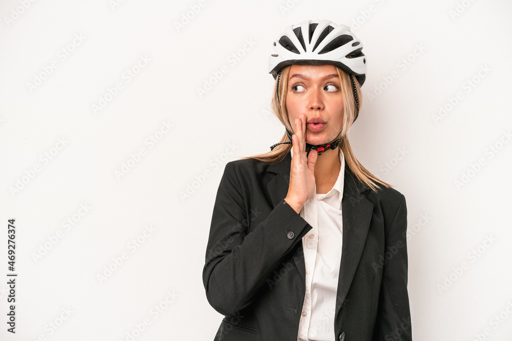 Young caucasian business woman wearing a bike helmet isolated on white background is saying a secret hot braking news and looking aside Young caucasian business woman wearing a bike helmet isolated on white background is saying a secret hot braking news and looking aside