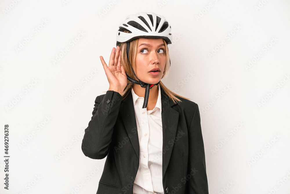 Young caucasian business woman wearing a bike helmet isolated on white background trying to listening a gossip. Young caucasian business woman wearing a bike helmet isolated on white background trying to listening a gossip.
