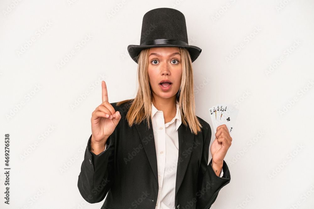 Young caucasian wizard woman holding magic card isolated on white background having an idea, inspiration concept. Young caucasian wizard woman holding magic card isolated on white background having an idea, inspiration concept.