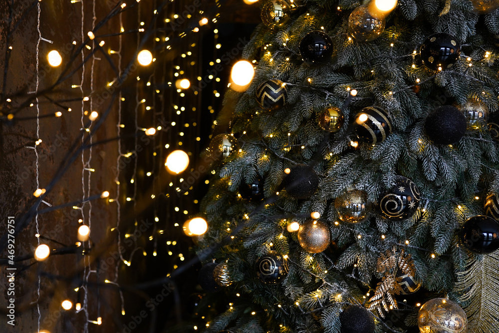 Christmas dark blurred background with a black Christmas tree, ornaments and bokeh lights Christmas dark blurred background with a black Christmas tree, ornaments and bokeh lights