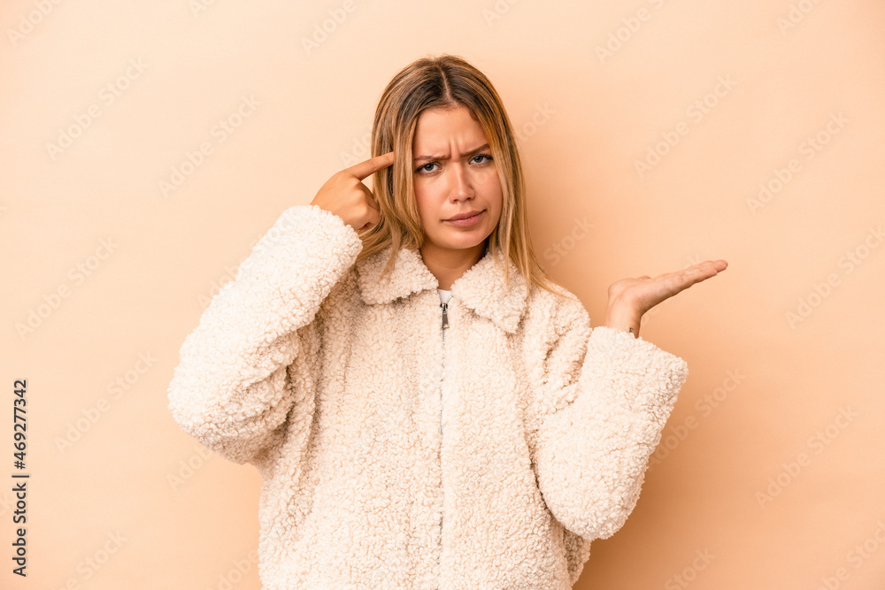 Young caucasian woman isolated on beige background showing a disappointment gesture with forefinger. Young caucasian woman isolated on beige background showing a disappointment gesture with forefinger.
