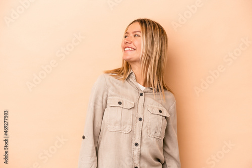 Young caucasian woman isolated on beige background relaxed and happy laughing, neck stretched showing teeth.