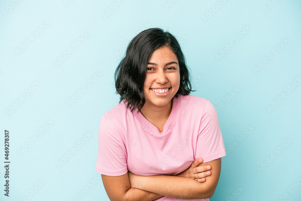Young latin woman isolated on blue background laughing and having fun.