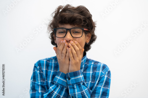 portrait of smart looking arab teenager with glasses wearing a hat in casual school look isolated on white copy space