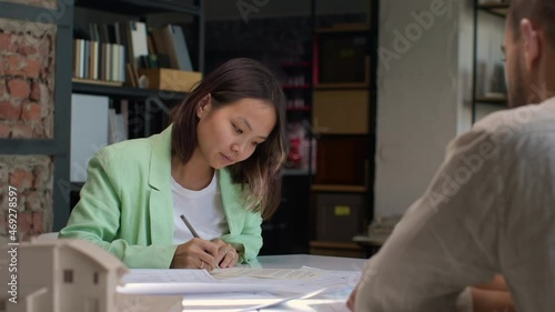 Home buyer at office room desk signing contract on buying real estate. Customer deal and purchasing residential house. Signature on official document for sell realtor. Asian female client paper work