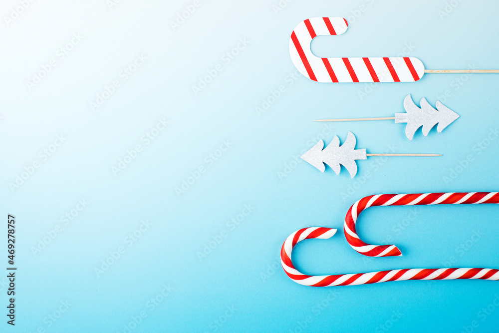Christmas red and white lollipops on a gradient blue background. Christmas background. Copy space. Flat lay.