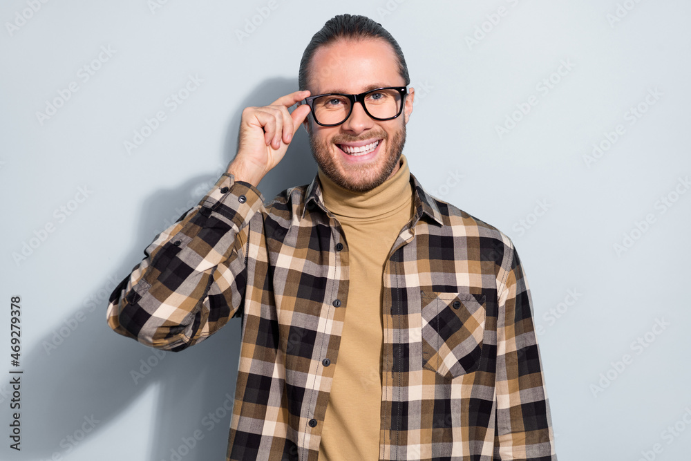 Photo of young cheerful guy hand touch eyeglasses agent representative isolated over grey color background Photo of young cheerful guy hand touch eyeglasses agent representative isolated over grey color background