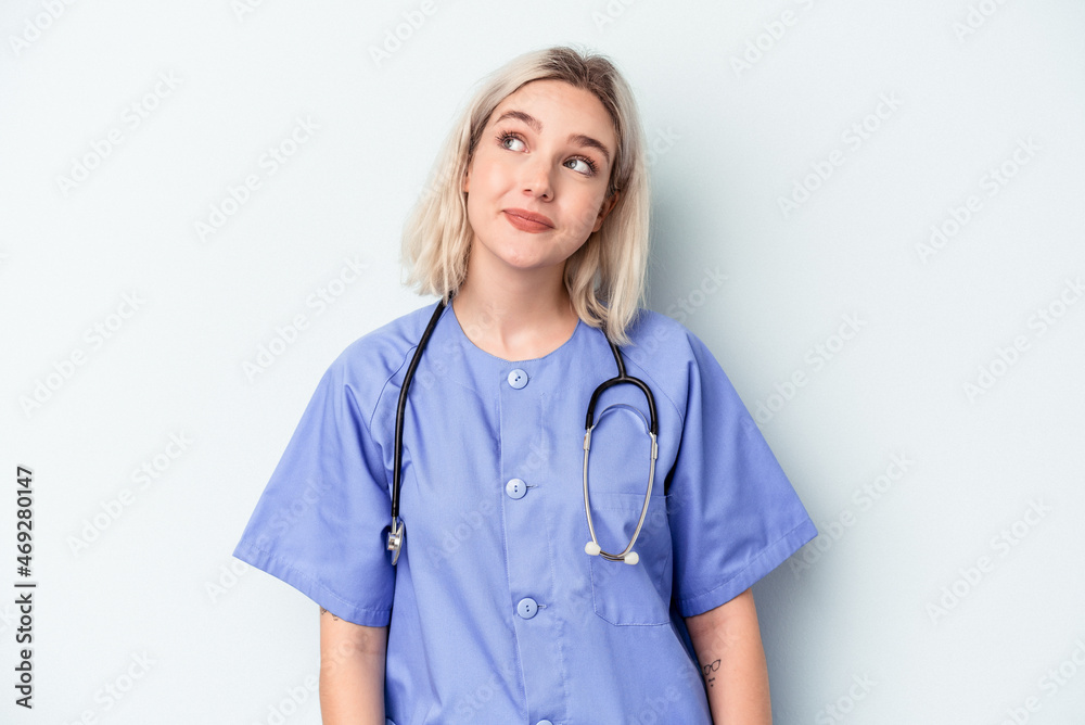 Young nurse woman isolated on blue background dreaming of achieving goals and purposes Young nurse woman isolated on blue background dreaming of achieving goals and purposes
