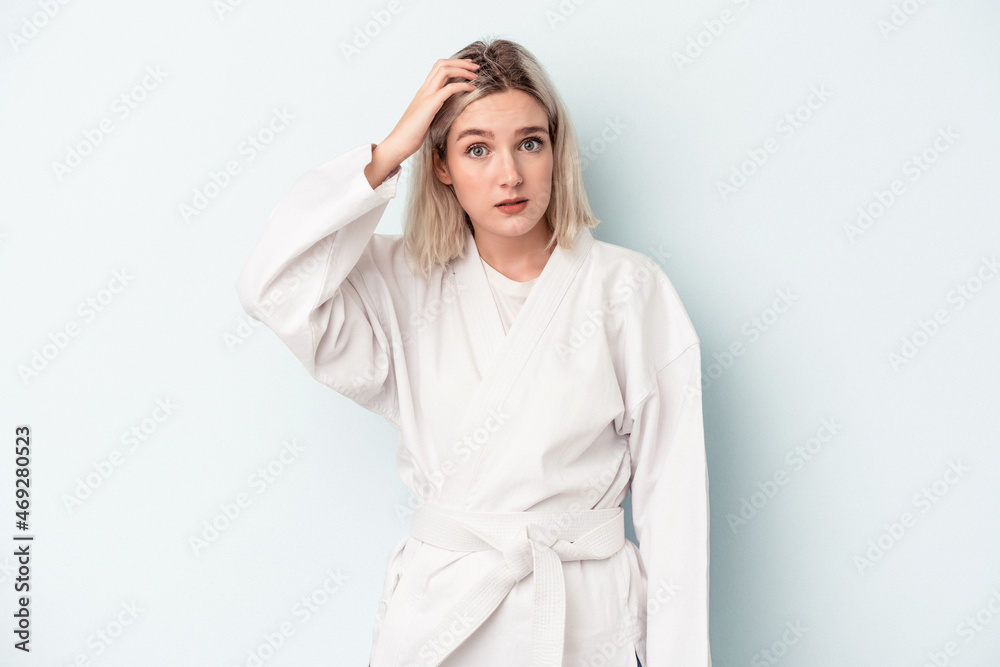 Young caucasian woman doing karate isolated on blue background being shocked, she has remembered important meeting. Young caucasian woman doing karate isolated on blue background being shocked, she has remembered important meeting.