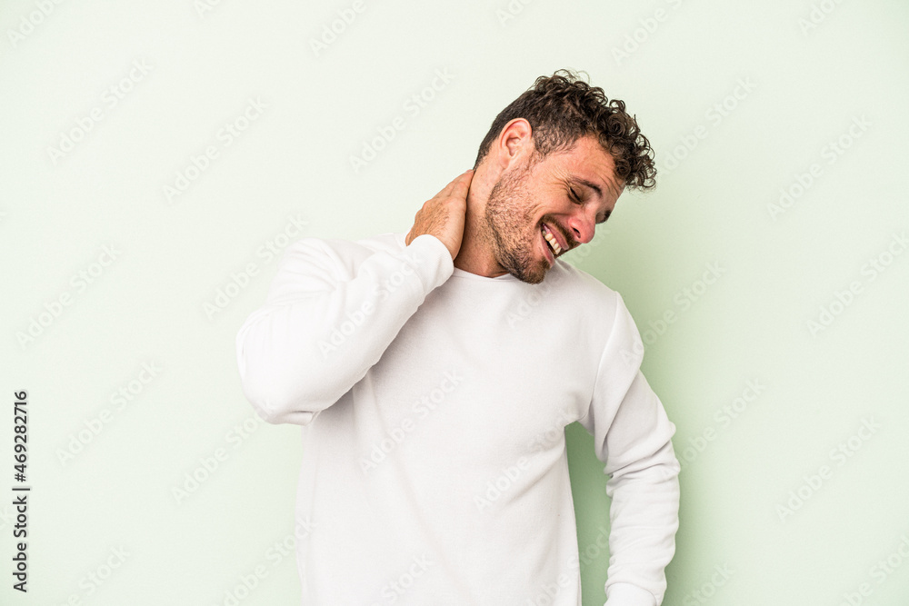 Young caucasian man isolated on green background suffering neck pain due to sedentary lifestyle. Young caucasian man isolated on green background suffering neck pain due to sedentary lifestyle.