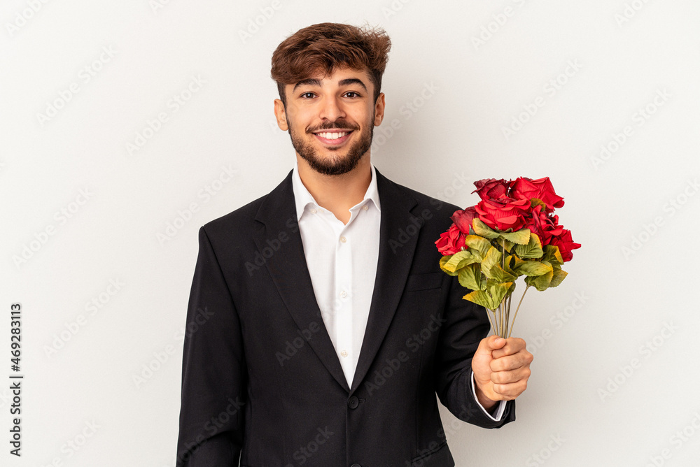 Young mixed race man holding bouquet of roses isolated on white background happy, smiling and cheerful. Young mixed race man holding bouquet of roses isolated on white background happy, smiling and cheerful.