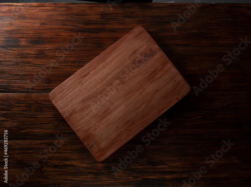 Tabla de madera rectangular vacía sobre mesa de madera. Empty rectangular wooden board on wooden table.
