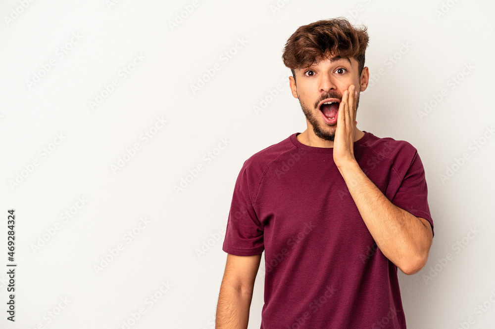 Young mixed race man isolated on grey background shouts loud, keeps eyes opened and hands tense. Young mixed race man isolated on grey background shouts loud, keeps eyes opened and hands tense.