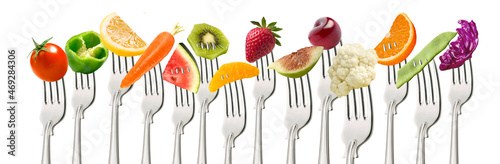 Fruta y verduras en tenedor sobre fondo blanco. Fruit and vegetables on fork on white background.