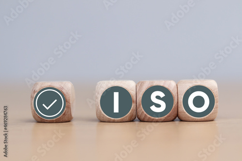 Wooden cube with the text ISO with check mark . ISO Quality Control Certification Concept © Sai
