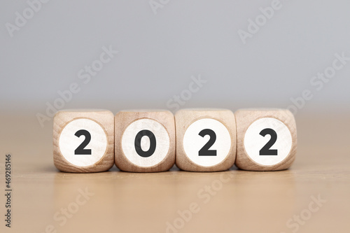 Wooden cube with 2022 text, concept to success of growing business. © Sai
