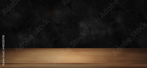 Wooden light table counter top with dark black background . Wood tabletop front view