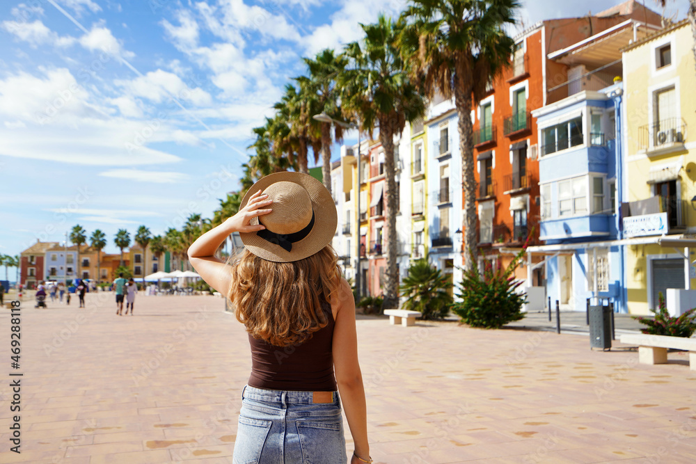 Tourism in Europe. Happy traveler girl visiting the colorful Spanish village with palm trees and beaches Villajoyosa, Alicante, Spain.