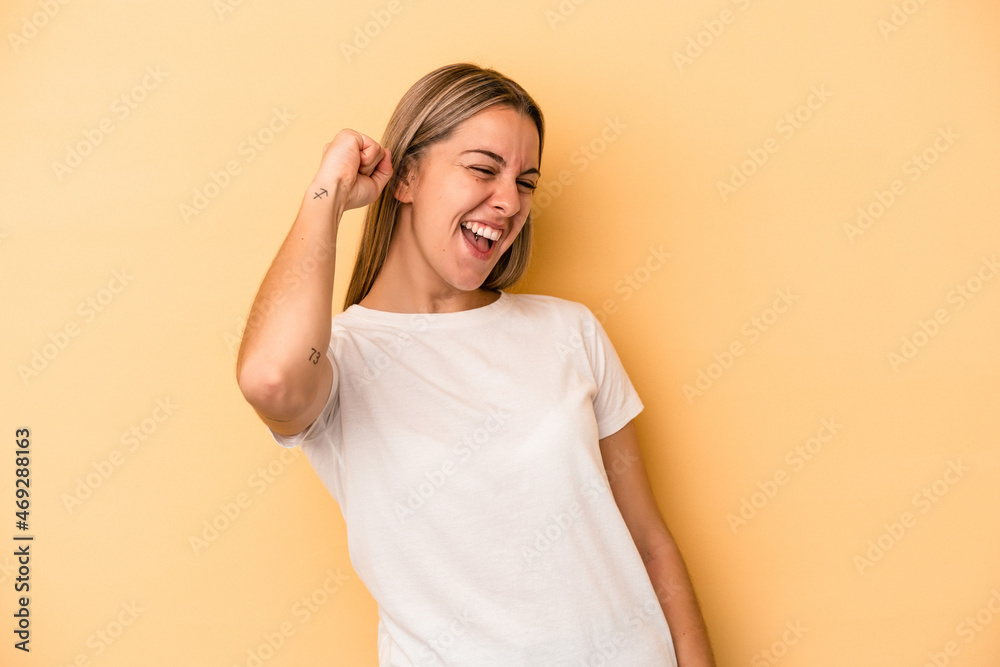 Young caucasian woman isolated on yellow background celebrating a victory, passion and enthusiasm, happy expression. Young caucasian woman isolated on yellow background celebrating a victory, passion and enthusiasm, happy expression.