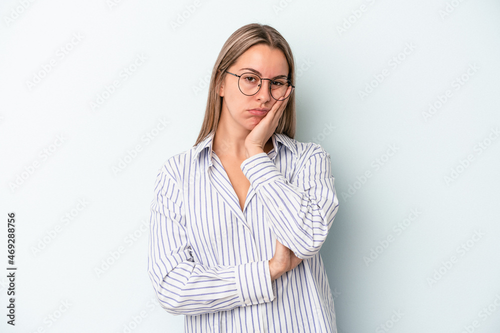 Young caucasian woman isolated on blue background who is bored, fatigued and need a relax day.