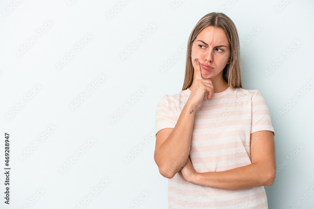 Young caucasian woman isolated on blue background looking sideways with doubtful and skeptical expression. Young caucasian woman isolated on blue background looking sideways with doubtful and skeptical expression.