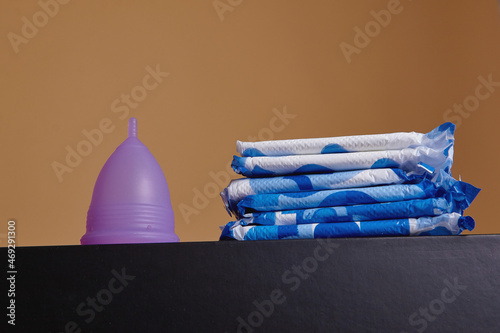 фотографія A silicone menstrual cup next to a stack of sanitary towels