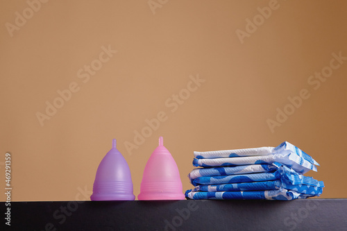 Canvas Print A silicone menstrual cup next to a stack of sanitary towels