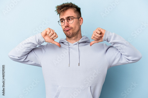 Young caucasian man isolated on blue background feels proud and self confident, example to follow. © Asier