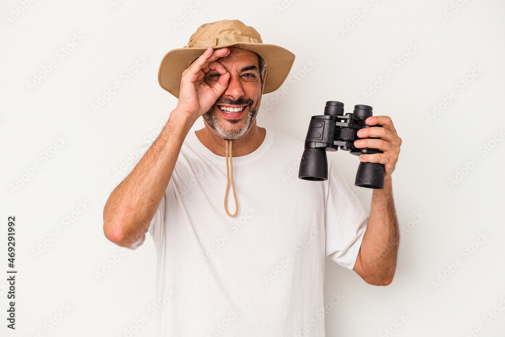 Middle age caucasian man holding binoculars isolated on white background excited keeping ok gesture on eye. Middle age caucasian man holding binoculars isolated on white background excited keeping ok gesture on eye.