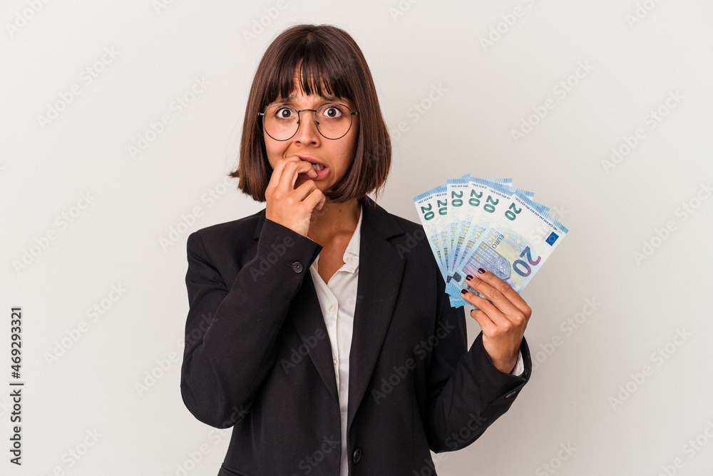 Young mixed race business woman holding a banknotes isolated on white background biting fingernails, nervous and very anxious. Young mixed race business woman holding a banknotes isolated on white background biting fingernails, nervous and very anxious.